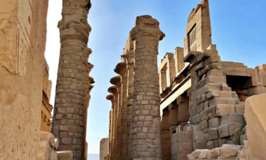 A breathtaking sunrise over the ancient Karnak Temple in Luxor, Egypt, with golden light illuminating massive stone columns and hieroglyphs, tourists exploring the site, the Nile River in the distance, realistic photography style, high detail, travel magazine quality.